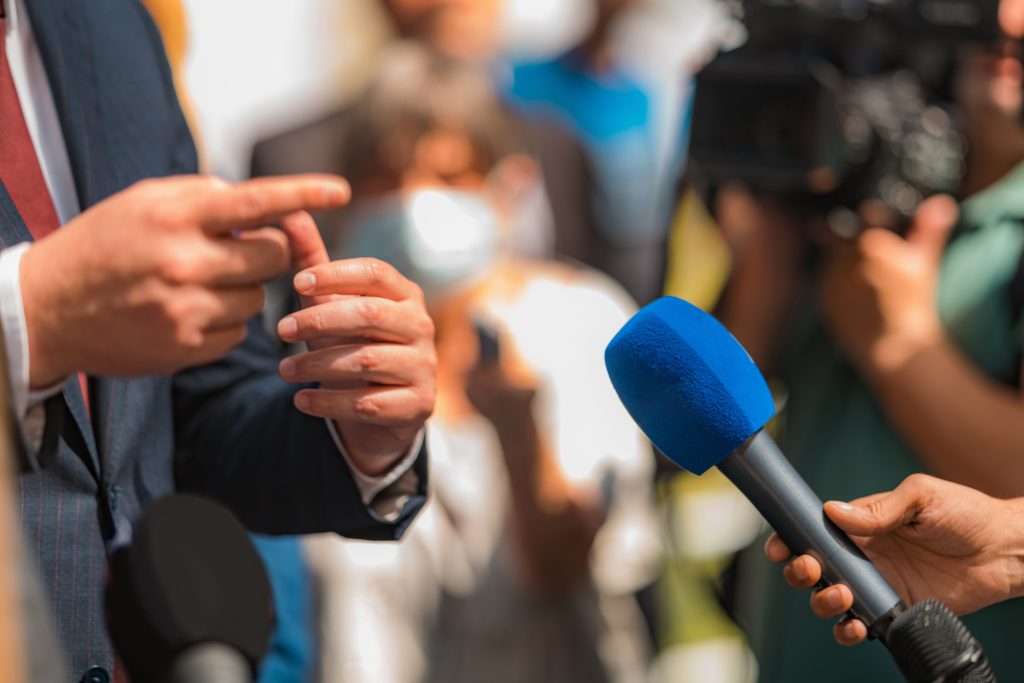 journalist conducting an interview, politician answering questions.