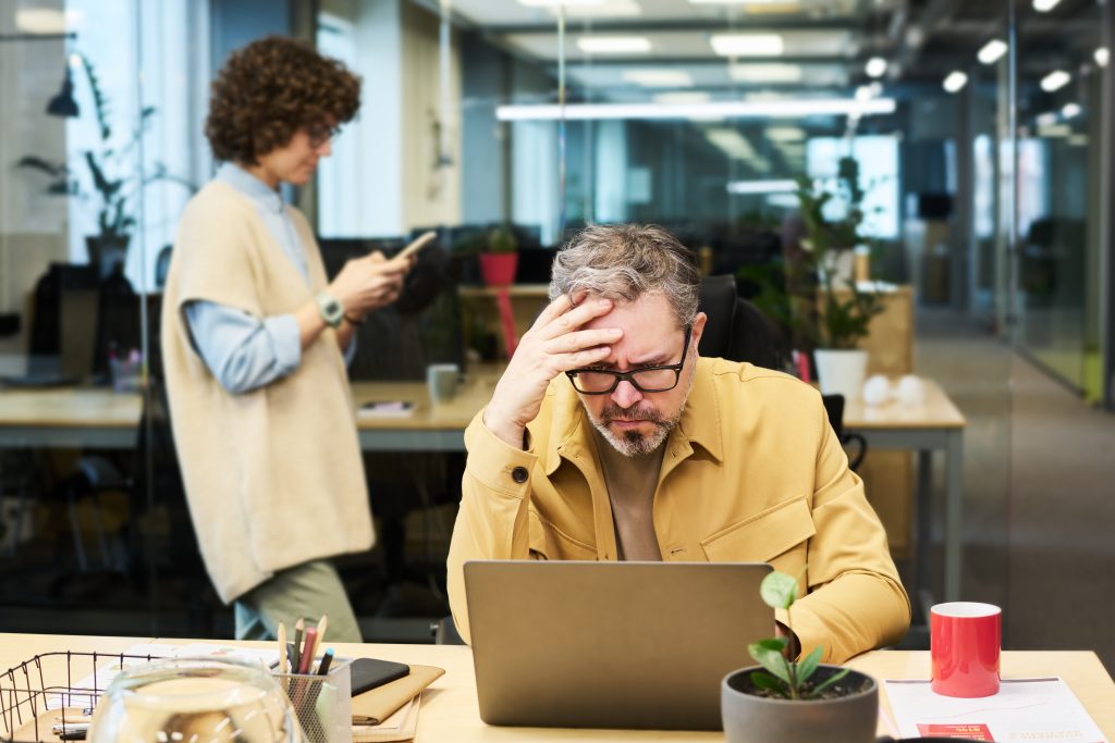 mature chief executive officer trying to understand data on laptop screen