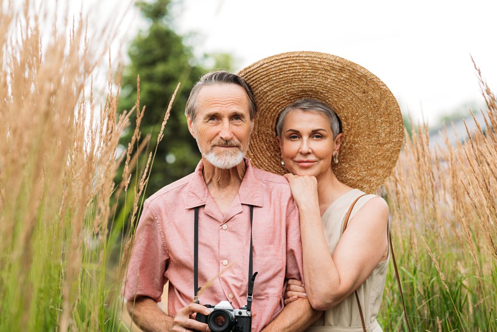 portrait of a senior couple looking at camera while standing outdoors