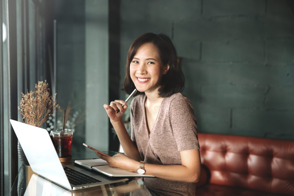 young business female hands using smart phone while working on c